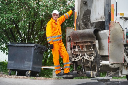 Workers using a builders skip for waste disposal